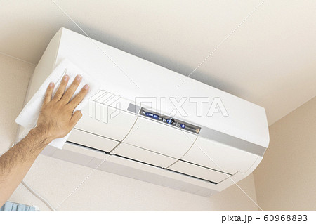 タオルでエアコンの外観を拭き掃除している男の手 60968893