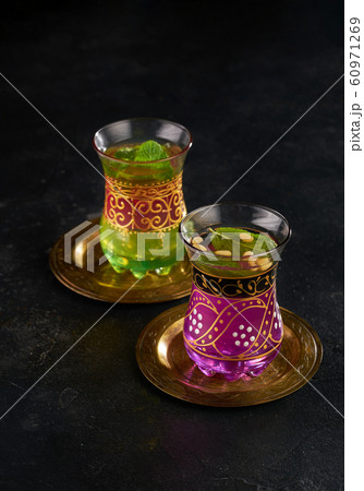 Moroccan mint tea in the traditional glasses on black background Moroccan mint tea in the traditional glasses on black background 60971269