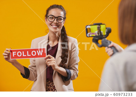 Contemporary Young Woman Holding Follow Word Contemporary Young Woman Holding Follow Word 60973233