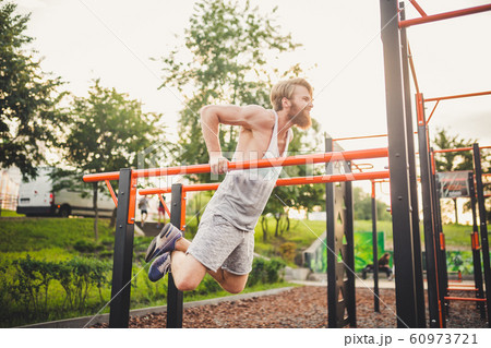 Fit Man Workout Out Arms On Dips Horizontal Bars Training Triceps And Biceps Doing Push Ups. Handsome Man Doing Exercise On Parallel Bars. Male Athlete Exercises On Parallel Bars Outdoor Fit Man Workout Out Arms On Dips Horizontal Bars Training Triceps And Biceps Doing Push Ups. Handsome Man Doing Exercise On Parallel Bars. Male Athlete Exercises On Parallel Bars Outdoor 60973721