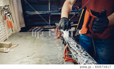 Applying hot wax to ski base with iron. Applying Ski Wax To Ski Base. Ski base tuning. Ski wax iron and wax bars. Ski service and repair. repairman in workshop ski service. Man Waxing Ski In Workshop Applying hot wax to ski base with iron. Applying Ski Wax To Ski Base. Ski base tuning. Ski wax iron and wax bars. Ski service and repair. repairman in workshop ski service. Man Waxing Ski In Workshop 60973817