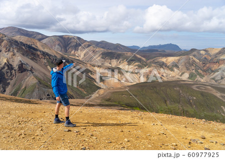 Hiker with backpack in the Landmannalaugar Valley. Iceland. Colorful mountains on the Laugavegur Hiker with backpack in the Landmannalaugar Valley. Iceland. Colorful mountains on the Laugavegur 60977925