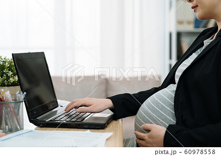 close up maternity abdomen by notebook pc close up maternity abdomen by notebook pc 60978558