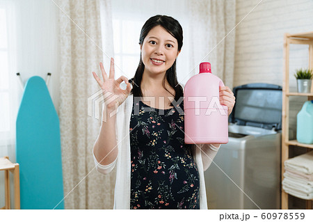 pregnant woman is holding fabric softener pregnant woman is holding fabric softener 60978559
