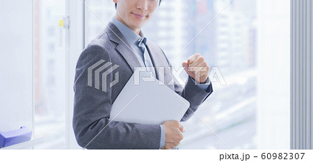 パソコンを持ったビジネスマン　男性　人物　日本人　やる気　自信　パソコン　営業　エンジニア　契約 60982307