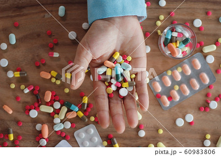 Medicine top view. Colorful capsules pills in hand over wooden table plenty of drugs spread on, Healthcare and medicine concept 60983806