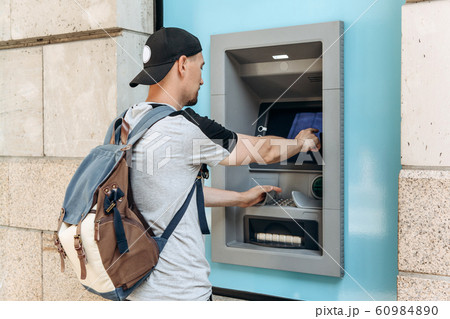 The tourist withdraws money from the ATM The tourist withdraws money from the ATM 60984890