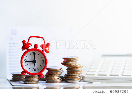 Red alarm clock on stack of coins in concept of savings and money growing.  60987292