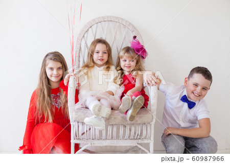 three little girls and a boy sitting at a friends party three little girls and a boy sitting at a friends party 60987966