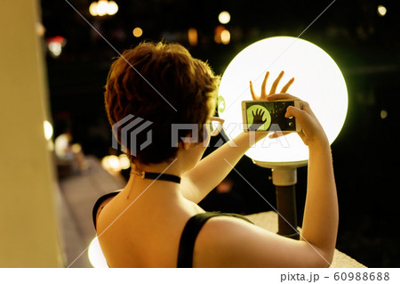 Young stylish girl in glasses with a short haircut making photo by phone Young stylish girl in glasses with a short haircut making photo by phone 60988688