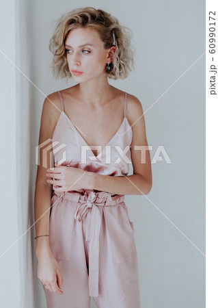 Portrait of a beautiful fashionable blonde woman in a pink jumpsuit 60990172