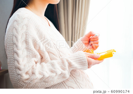 薬ケースから取り出す妊婦 60990174