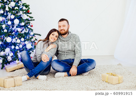 husband and wife on Christmas trees offer gifts for the new year husband and wife on Christmas trees offer gifts for the new year 60991915