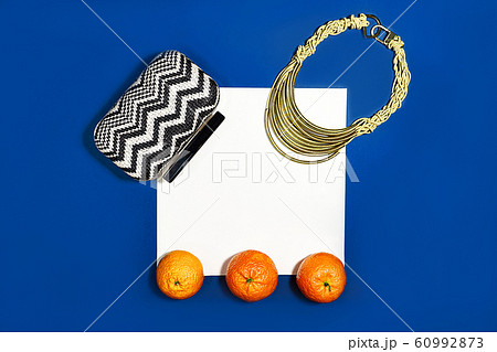 Female fashion layout with white paper sheet, orange tangerines and female accessories on classic 60992873