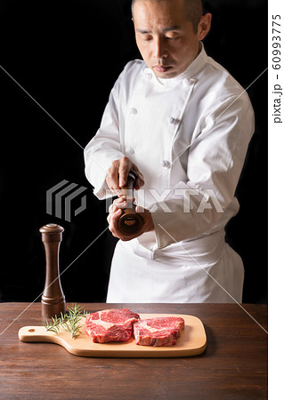 牛肉に胡椒をふりかけるシェフ 牛肉に胡椒をふりかけるシェフ 60993775