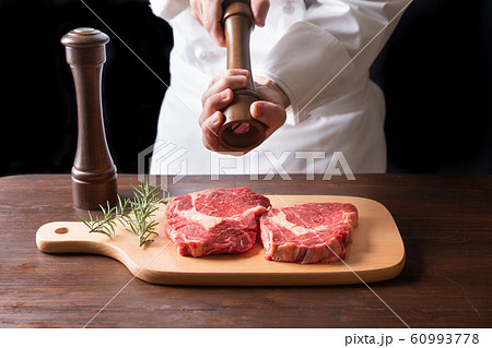 牛肉に胡椒をふりかけるシェフ 牛肉に胡椒をふりかけるシェフ 60993778