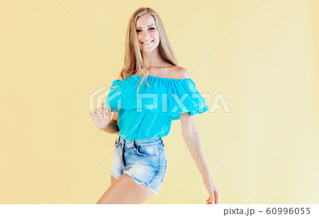 blonde girl in a blue dress, on a yellow background blonde girl in a blue dress, on a yellow background 60996055