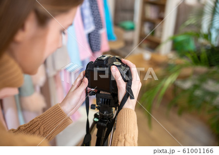 Photographer setting her camera on the tripod 61001166