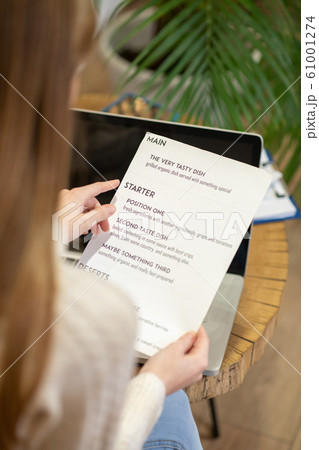 Long-haired woman working with the menu card Long-haired woman working with the menu card 61001274