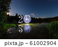 2020 written on the air with glowing ball mirrored on surface of water 61002904