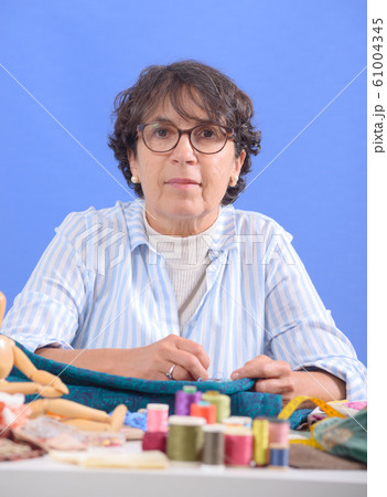 mature brunette woman sewing patchwork 61004345