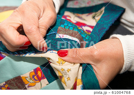 woman sewing for finish a quilt. 61004768
