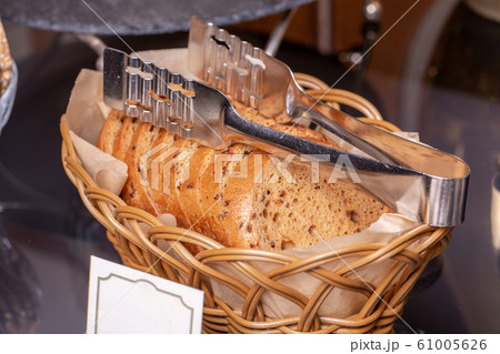Gluten-free bread in a braided basket with tongs Gluten-free bread in a braided basket with tongs 61005626