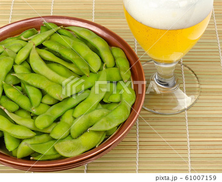 Boiled edamame in a bowl with a glass of beer Boiled edamame in a bowl with a glass of beer 61007159