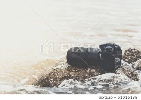 DSLR camera on stone beach wet from water sea wave 61016138