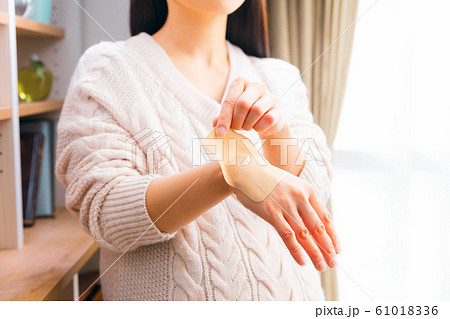 湿布を貼る妊婦 手首 湿布を貼る妊婦 手首 61018336