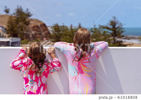 Sisters Looking Over Wall At View 61018808