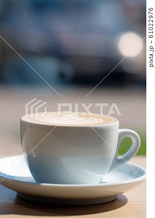 a cup of coffee stands on a wooden table side view 61022976