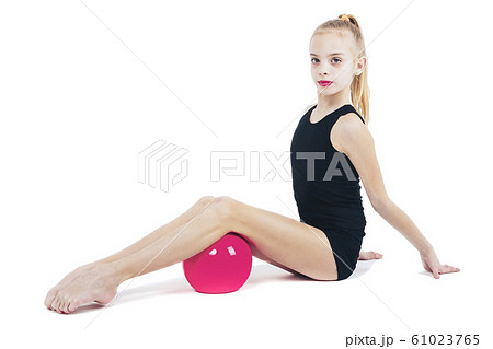 Young girl gymnast sitting with a red ball Young girl gymnast sitting with a red ball 61023765