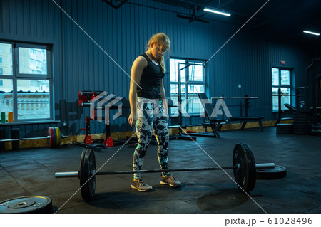 Caucasian teenage girl practicing in weightlifting in gym Caucasian teenage girl practicing in weightlifting in gym 61028496
