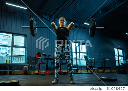 Caucasian teenage girl practicing in weightlifting in gym Caucasian teenage girl practicing in weightlifting in gym 61028497