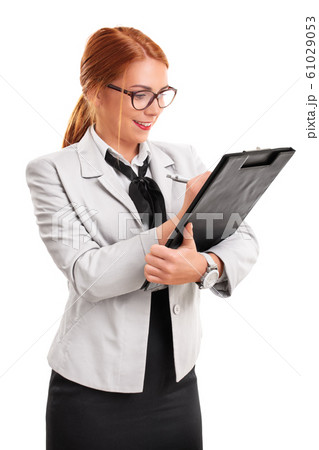 Young fashionable businesswoman writing on a clipboard 61029053