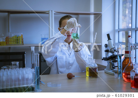 Female scientists lifted graduated cylinder. Look Female scientists lifted graduated cylinder. Look 61029301