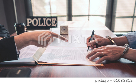 suspect with handcuffs being interviewed in suspect with handcuffs being interviewed in 61035815
