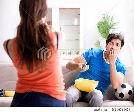 Wife unhappy that husband is watching football Wife unhappy that husband is watching football 61035937