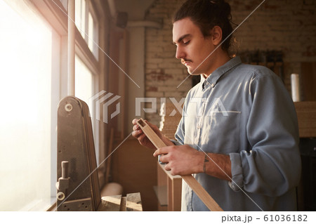 Man working with wood on lathe 61036182