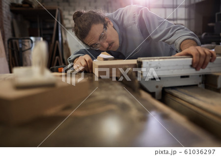 Man measuring the wooden plank Man measuring the wooden plank 61036297
