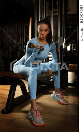 Young pretty girl doing exercises with dumbbells Young pretty girl doing exercises with dumbbells 61037694