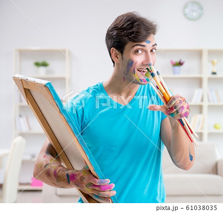Young funny artist working on new painting in his studio 61038035
