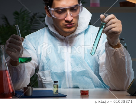 The young male lab chemist late at night in overtime time 61038871