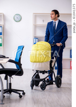 Young father looking after newborn in the office 61041375