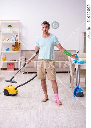 Young injured man cleaning the house 61042800
