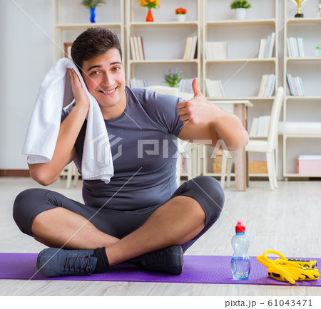 Young man exercising at home in sports and healthy lifestyle con Young man exercising at home in sports and healthy lifestyle con 61043471