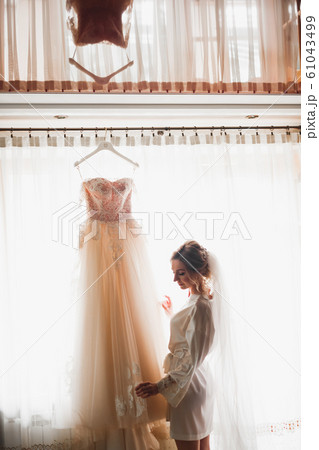 Luxury bride in white dress posing while preparing for the wedding ceremony Luxury bride in white dress posing while preparing for the wedding ceremony 61043499