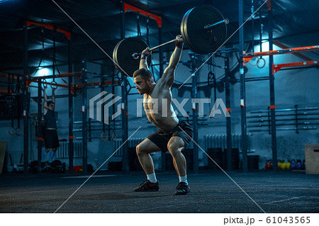 Caucasian man practicing in weightlifting in gym 61043565