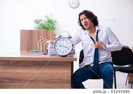 Young male employee unhappy with excessive work Young male employee unhappy with excessive work 61043986